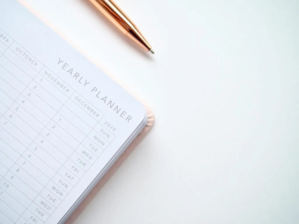 A yearly planner open on a desk with a pen, ready to plan the year ahead